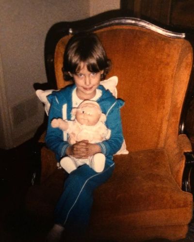 Picture of Deanna Russo during her childhood with her favorite toy in her hand.